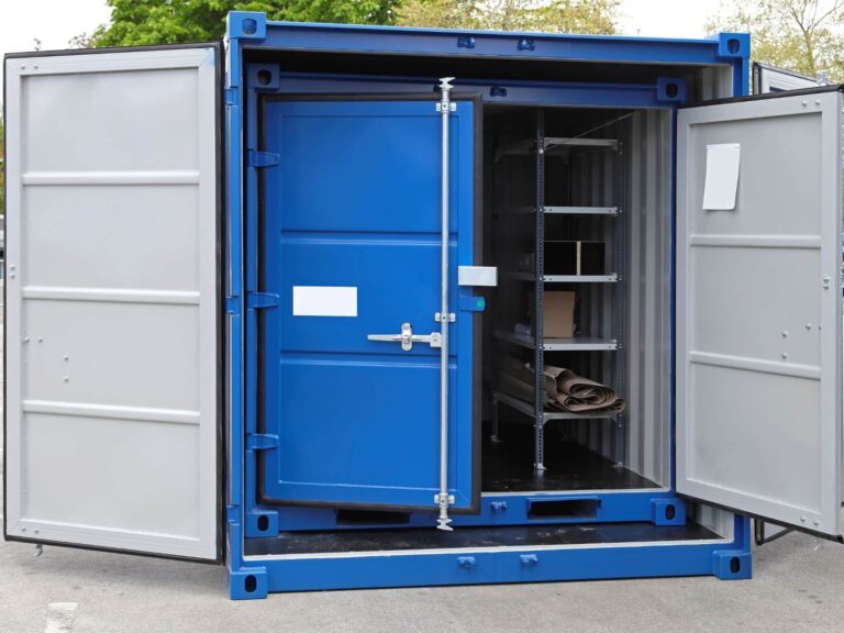 Blue steel storage container with doors open, revealing shelving and stored items inside, set outdoors with trees in the background.