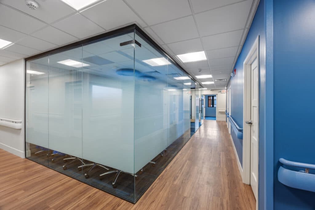 Glass-walled observation room off the corridor in the permanent modular school building