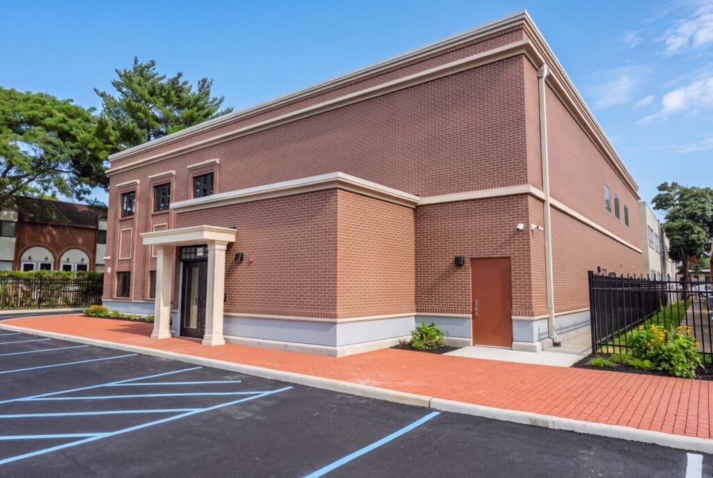 Two-story permanent modular school building for Kulanu in Cedarhurst, NY, brick exterior with entrance portico side