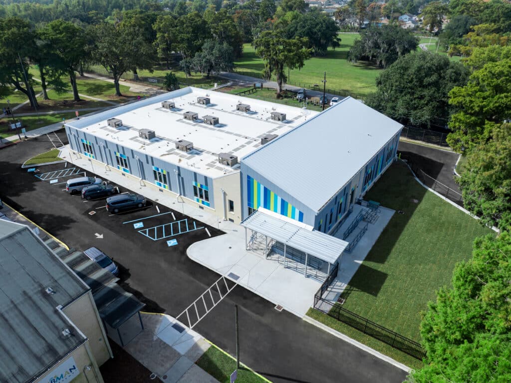 Aerial view of the 16,000 sq ft modular school building on the Tubman Park Campus, beside the playing field and parking