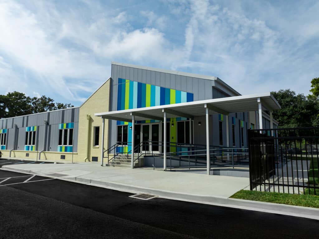 Crescent School, Front of the building outside. Permanent modular school building for the Constellations program in New Orleans, with grey and cream panelled facade and coloured window accents