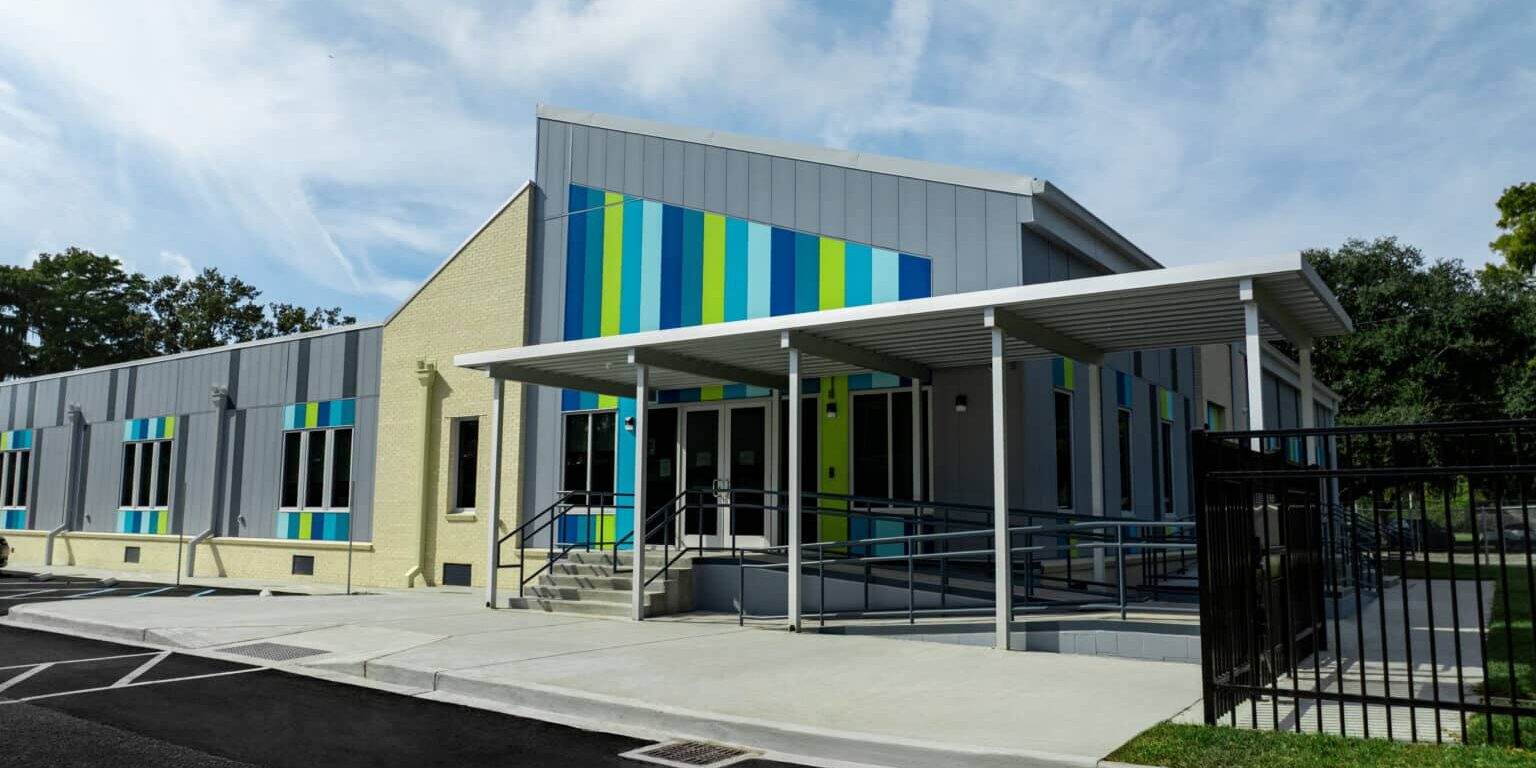 Crescent School, Front of the building outside. Permanent modular school building for the Constellations program in New Orleans, with grey and cream panelled facade and coloured window accents