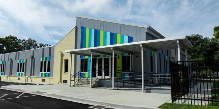 Modular classroom building with a covered walkway, entrance ramp and coloured panel accents on a school campus